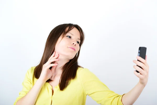 Beautiful woman taking selfies against white background — Stock Photo, Image