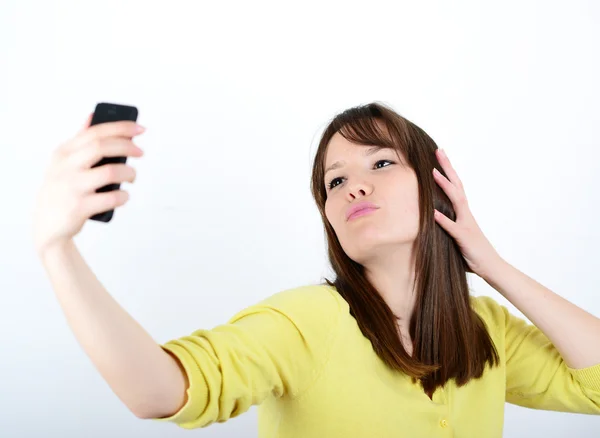 Beautiful woman taking selfies against white background — Stock Photo, Image