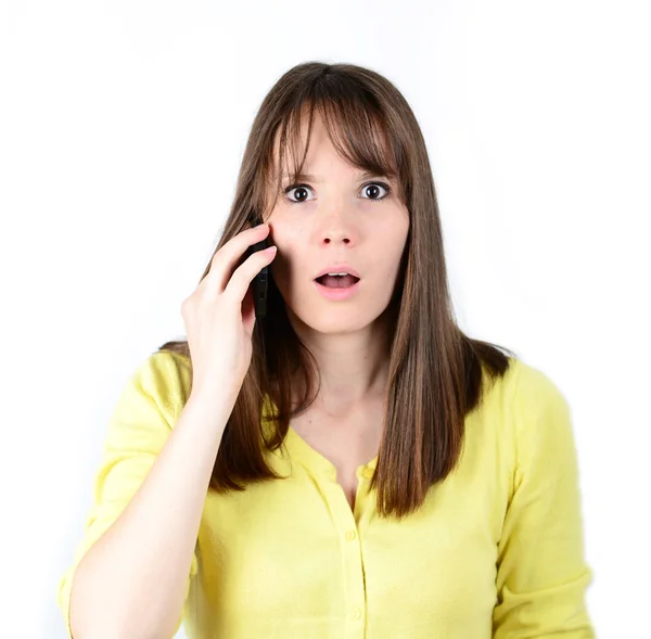 Mooie vrouw praten over cellphone en wordt in schok van nieuws — Stockfoto