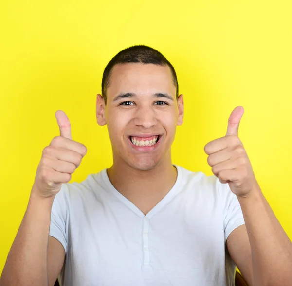 Portrait of with funny expression holding thumbs up against yell — Stock Photo, Image