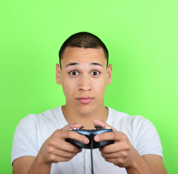 Retrato de un joven sosteniendo el controlador de juego y jugando juegos —  Fotos de Stock