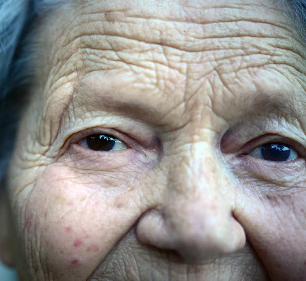 Portret van een aantrekkelijke vrouw met krullend haar zitten buiten — Stockfoto