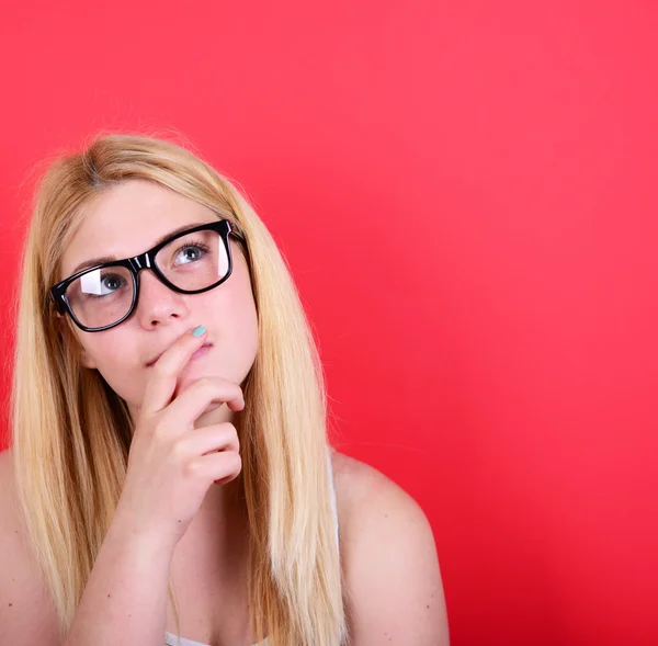 Portrait of beautiful girl looking up against red background — Stock Photo, Image