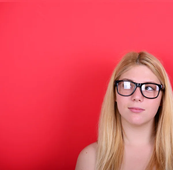 Porträt eines schönen Mädchens, das gegen rotes b denkt und aufblickt — Stockfoto