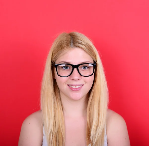 Portrait of beautiful happy young woman against red background — Stockfoto