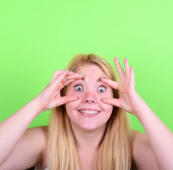 Porträt eines Mädchens mit lustigem Gesicht vor grünem Hintergrund — Stockfoto