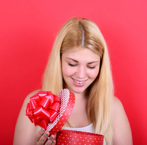快乐女人在红色背景下打开礼品盒的肖像 — 图库照片