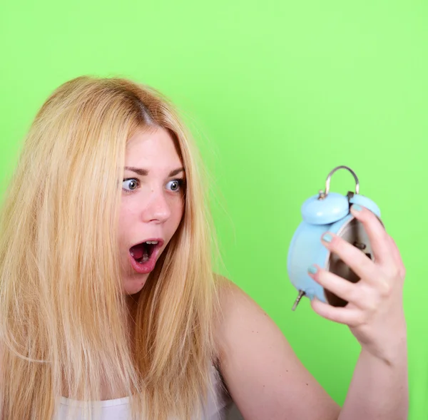 Porträt einer verschlafenen jungen Frau im Chaos, die Uhr gegen g hält — Stockfoto