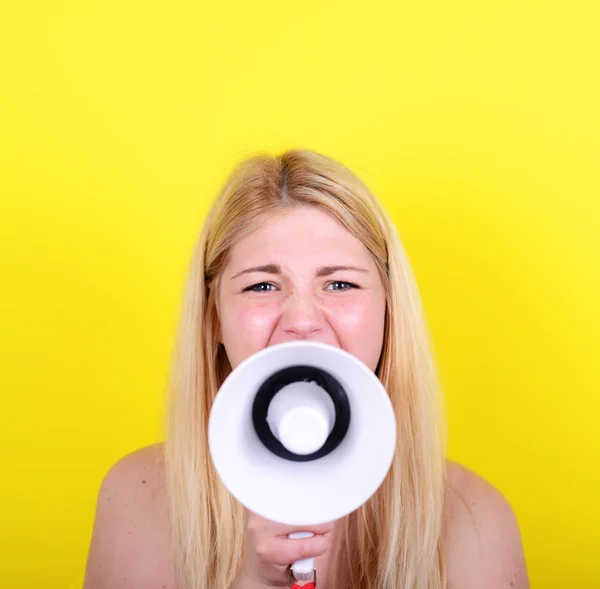 Portrait de jeune femme criant avec un mégaphone contre le jaune — Photo
