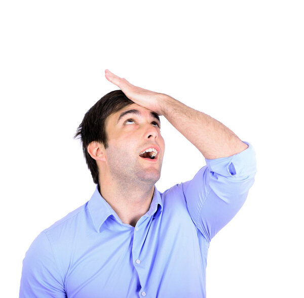 Portrait of young businessman slapping hand on head having a duh