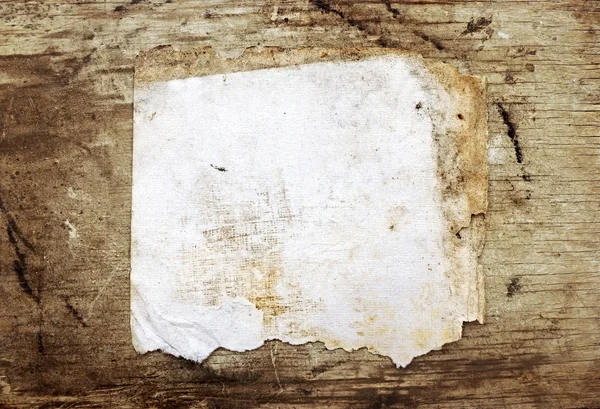 Old grungy paper on old wooden background — Stock Photo, Image