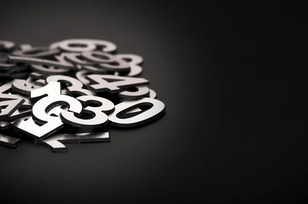 Closeup image with pile metal numbers on black background, space — Stock Photo, Image