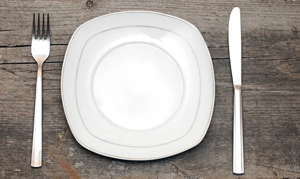 Empty dish knife and fork on wood table — Stock Photo, Image