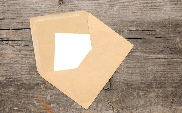 Papel em branco e envelope no fundo de madeira velho — Fotografia de Stock