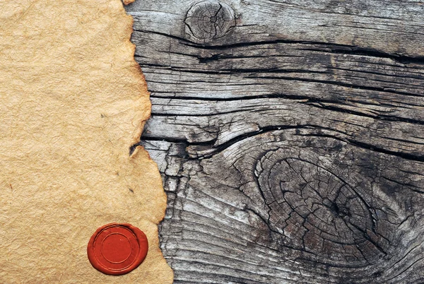 Papel desgarrado en blanco con sello de cera sobre fondo de madera viejo — Foto de Stock