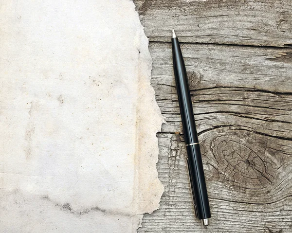 Stift auf altem Papier über altem Holztisch — Stockfoto