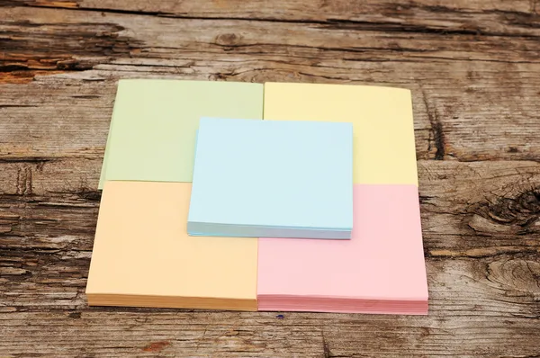 Pilha de notas coloridas pegajosas no fundo de madeira — Fotografia de Stock