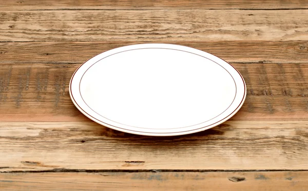 Plato blanco vacío sobre mesa de madera — Foto de Stock