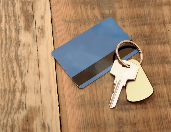 Key with plastic card on wooden background — Stock Photo, Image