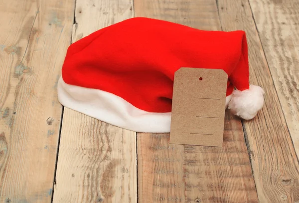 Brown sale tag on a baby sized Santa hat. — Stock Photo, Image