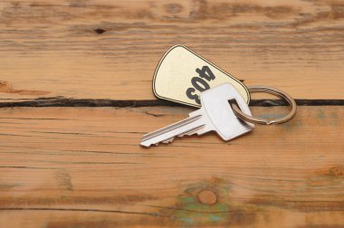 Gümüş anahtar ahşap zemin üzerine altın etiketi