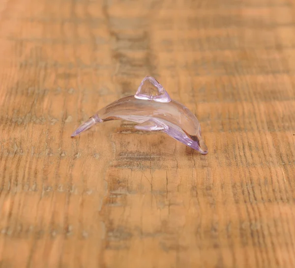 Closeup hračka sklo delfín na dřevěné pozadí — Stock fotografie