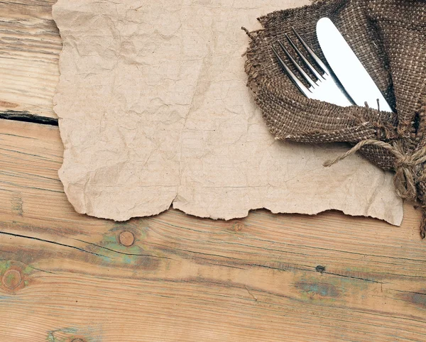 A place setting with silver fork and knife on old sacking textur — Stock Photo, Image