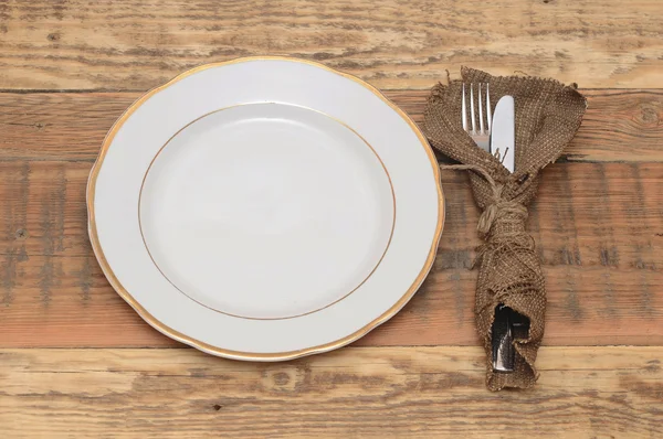 Assiette vide avec fourchette et couteau sur table en bois. — Photo