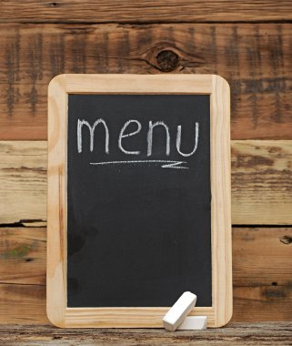 Yaşlı siyah menü yazı tahtası ahşap arka plan üzerinde