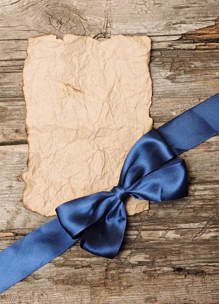 Boş boşaltmak için metin ile eski bir kağıt üzerinde mavi yay — Stok fotoğraf