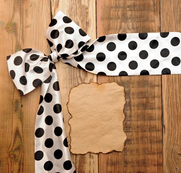 White bow with black dot on wooden background with copyspace for — Stock Photo, Image