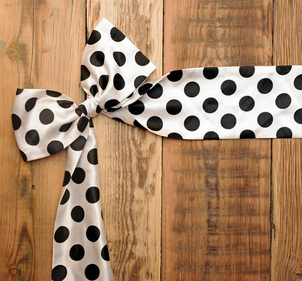 White bow with black dot on wooden background with copyspace for — Stock Photo, Image