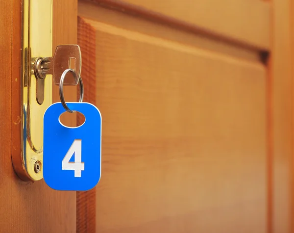 Drzwi drewno i klucz w dziurkę od klucza z numerowane etykiety — Zdjęcie stockowe