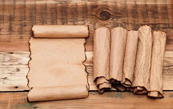 Papel de hoja viejo en blanco con rollos de pila sobre fondo de madera viejo — Foto de Stock