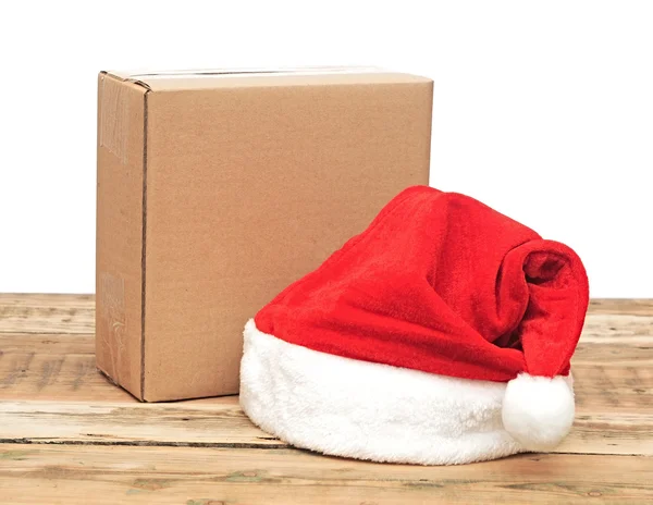 白上棕色纸板箱的圣诞老人帽子 — 图库照片