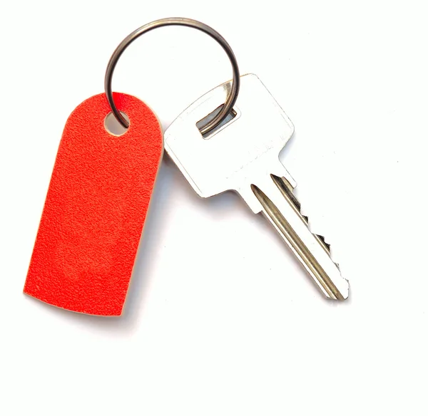 Etiqueta em branco e uma chave isolada no fundo branco — Fotografia de Stock