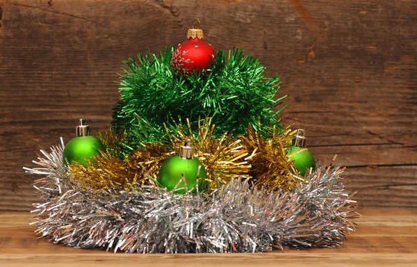 Christmas tree made of tinsel with christmas balls on a wooden t — Stock Photo, Image