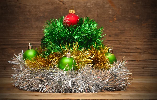 Kerstboom gemaakt van klatergoud met Kerstmis ballen op een houten t — Stockfoto