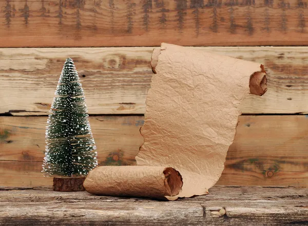 Pequeño árbol de navidad de juguete con pergamino de papel viejo —  Fotos de Stock