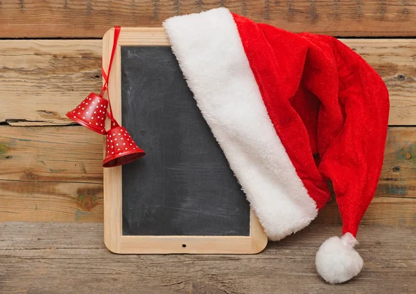 サンタの帽子のクリスマスの装飾を持つ空白の黒板 — ストック写真