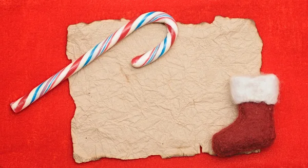 Rode Kerstmis achtergrond met blanco papier blad en candy cane — Stockfoto