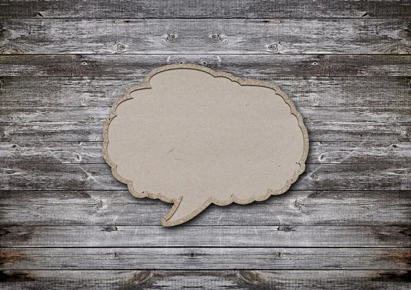 Blank recycled paper speech bubble on wood background — Stock Photo, Image