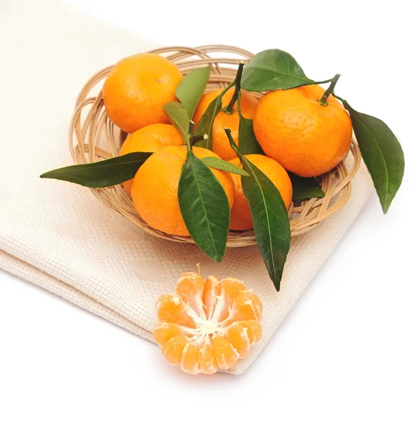Mandarinen mit Blättern in einem schönen Korb auf weiß — Stockfoto