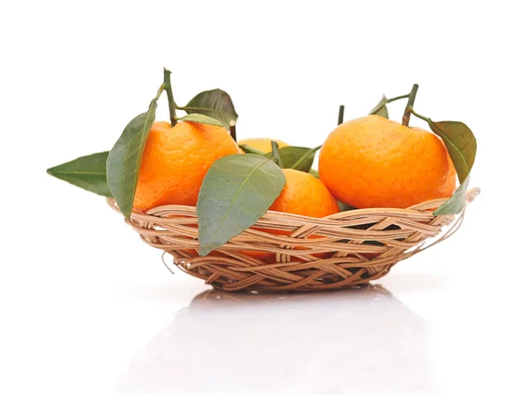 Tangerines with leaves in a beautiful basket on white Stock Photo