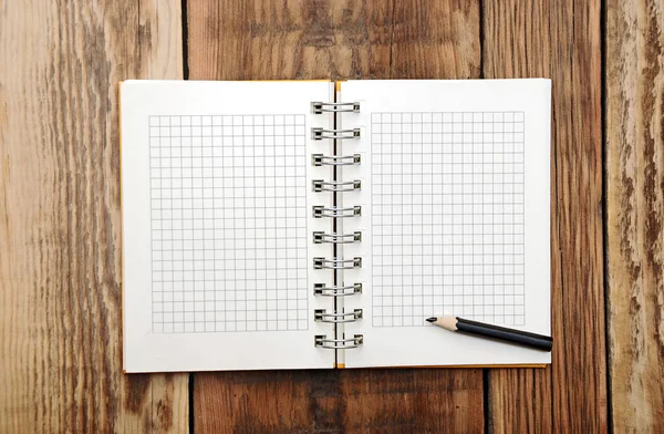 Un cuaderno abierto con lápiz sobre un escritorio de madera — Foto de Stock