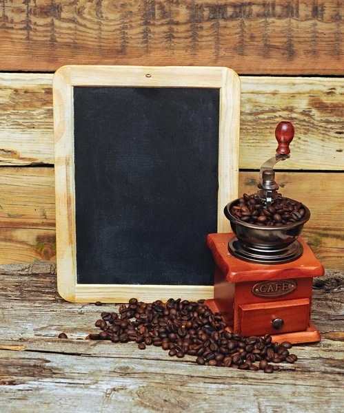 コーヒーミルと木製の背景の上に空白の黒板 — ストック写真