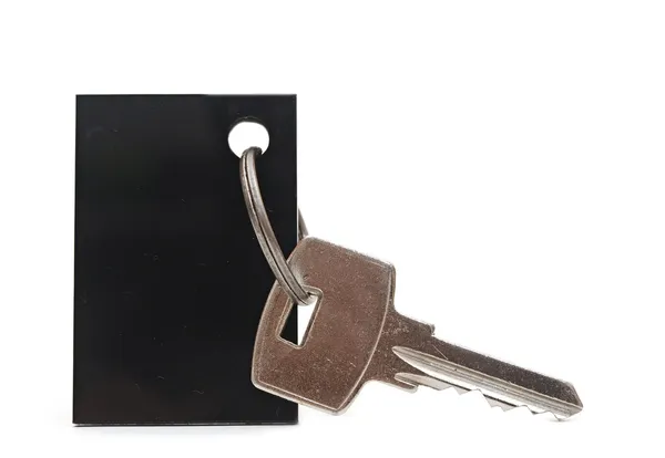 Etiqueta em branco e uma chave isolada no branco — Fotografia de Stock