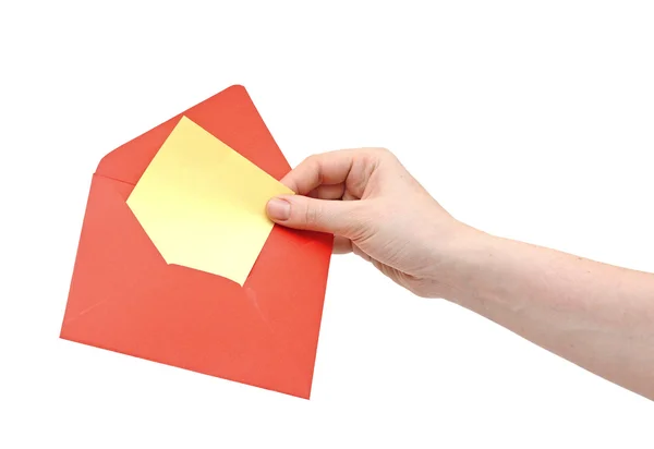 Рука держа красный конверт на белом фоне — стоковое фото