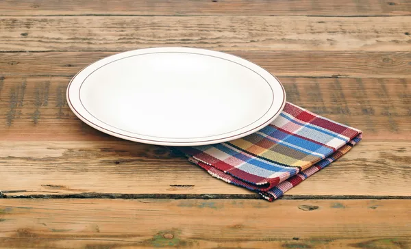 Empty white plate on wooden table — Stock Photo, Image