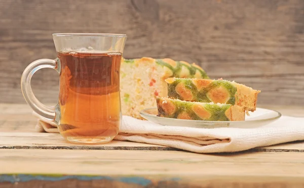 Lahodný sladký koláč s čajem na na dřevěný stůl — Stock fotografie